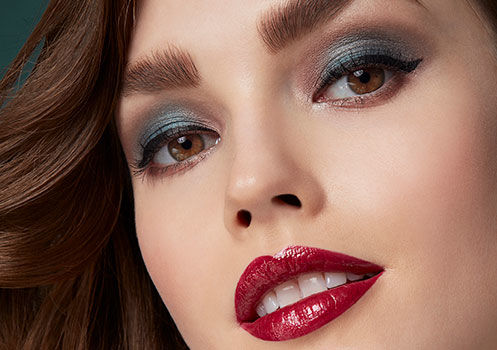 Ein Model mit einem starken Augen-Make-up und rot geschminkten Lippen